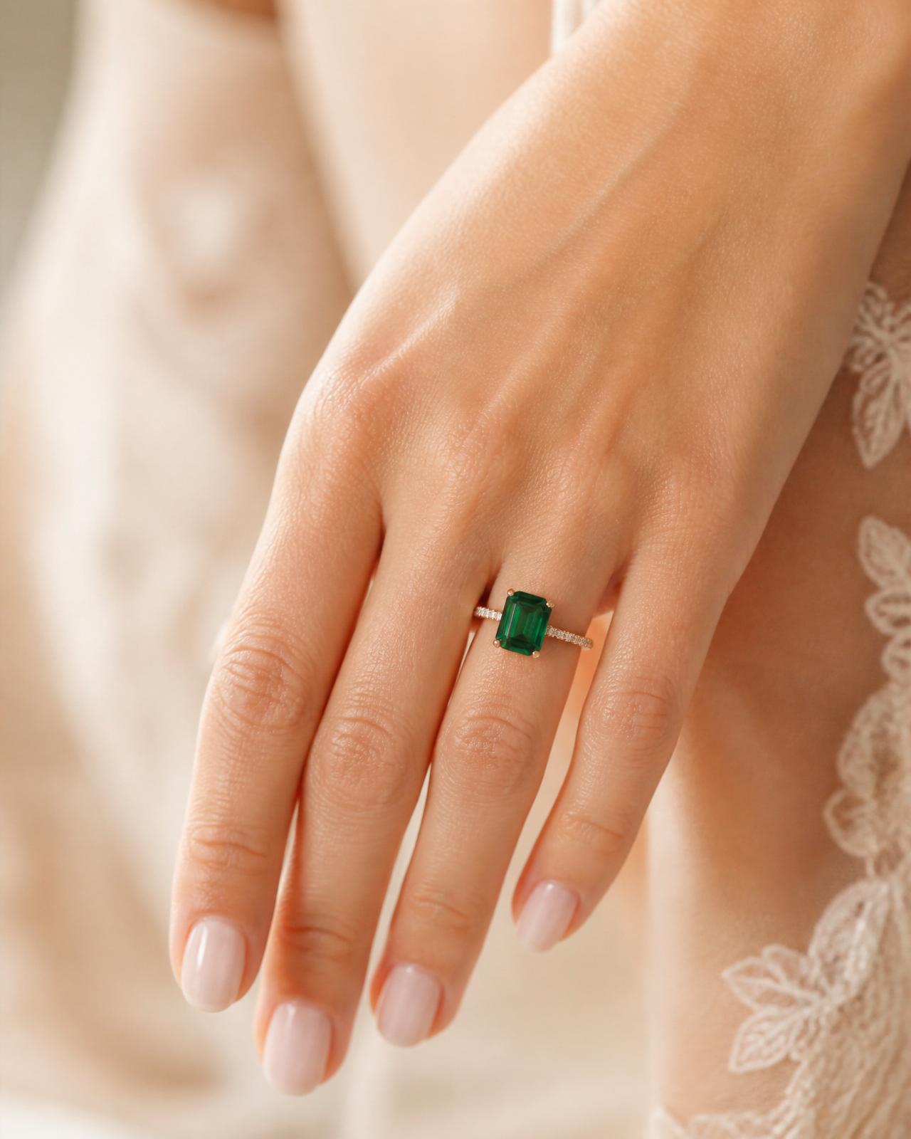 Close-up of a woman's hand wearing an emerald-cut diamond engagement ring at true scale, size 6½